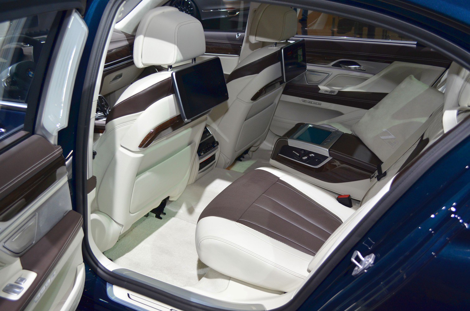 Luxury rear seat with dual screens, leather upholstery, and control panel.