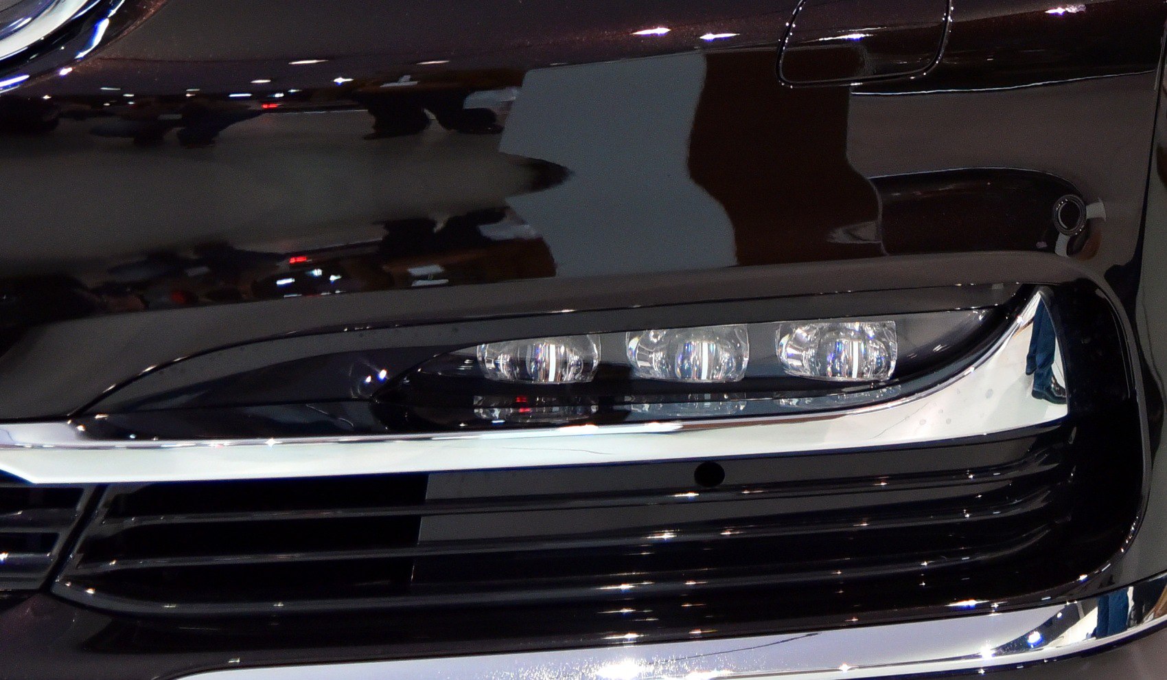 Close-up of LED headlight with chrome grille trim
