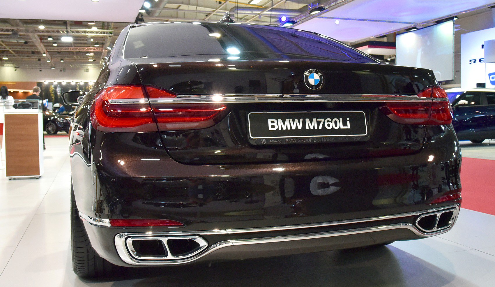 Luxury sedan rear with distinctive taillights and dual chrome exhausts