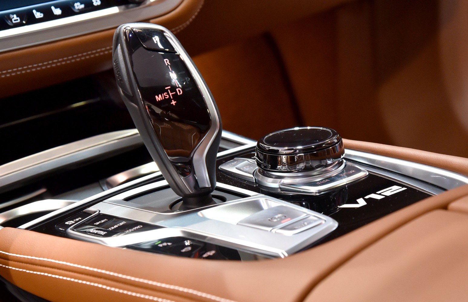 Luxury gear selector and rotary control knob on brown leather interior