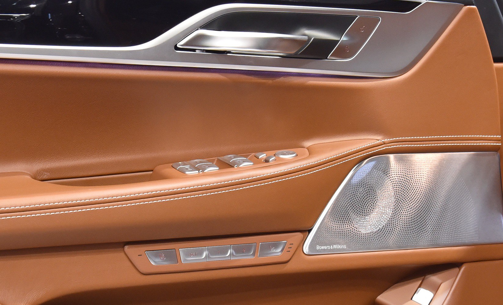 Brown leather door panel with speaker and control buttons