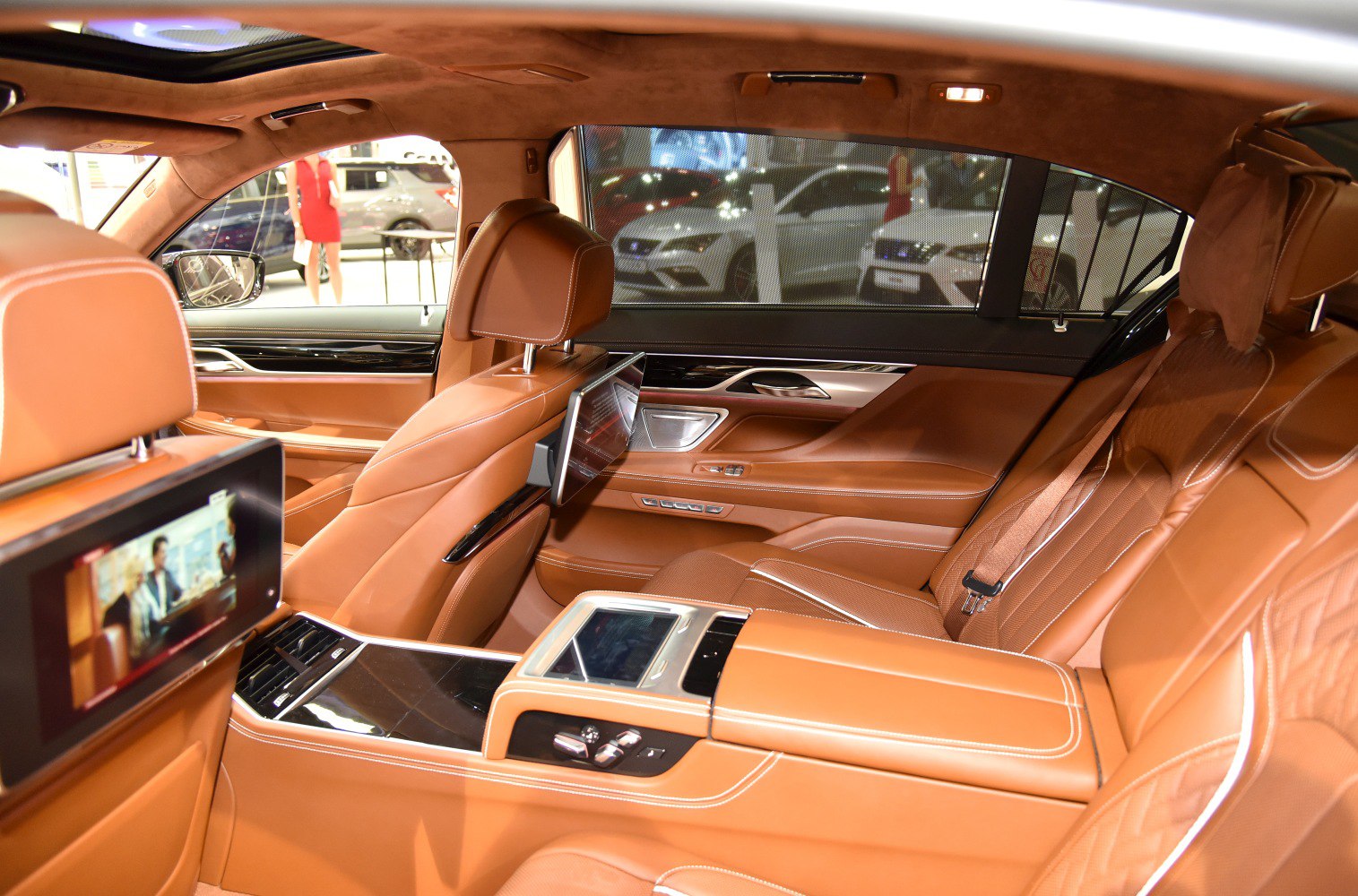 Tan leather rear seats with integrated entertainment screens and advanced rear seat controls