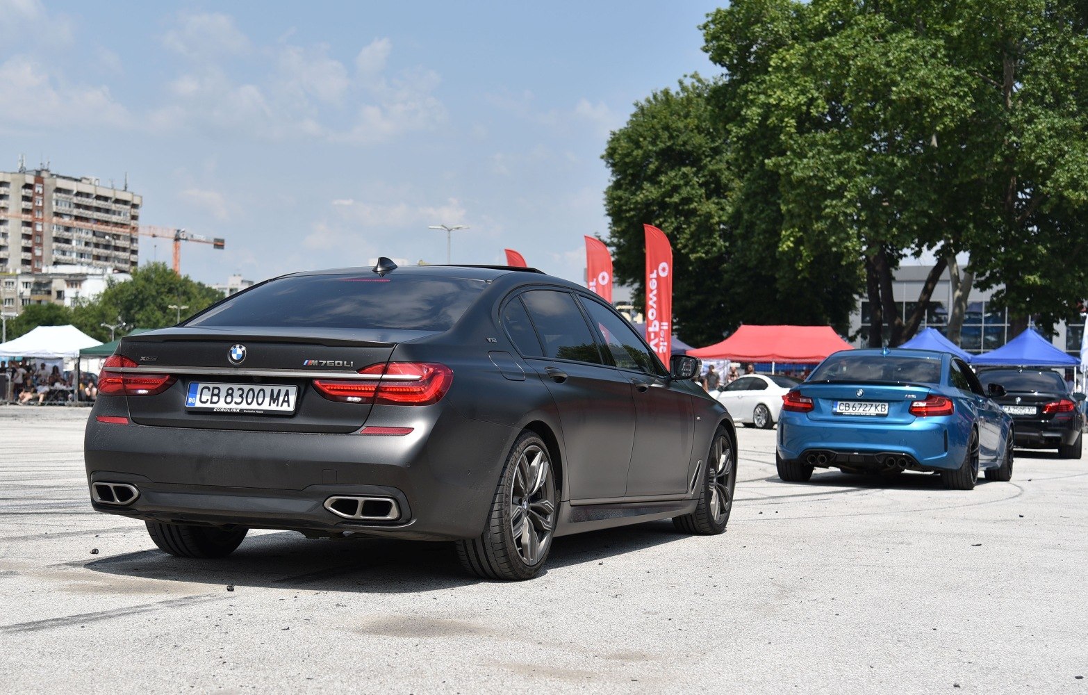 Matte black luxury sedan rear with quad exhausts and tail lights