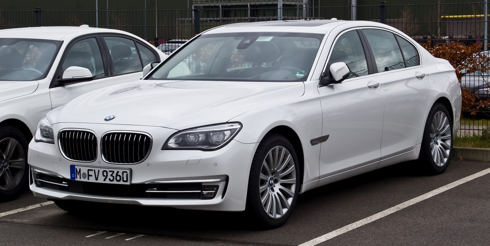 Front and side view of a luxury white sedan with LED headlights and alloy wheels