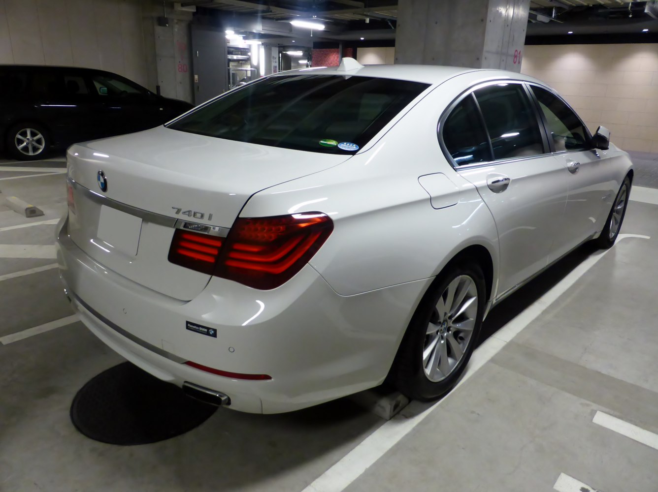 Rear view of luxury sedan with LED taillights and alloy wheels.