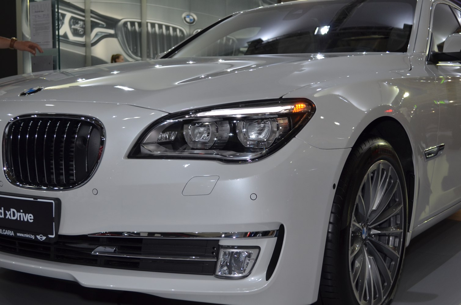 Close-up of front headlight and chrome grille with wheel detail