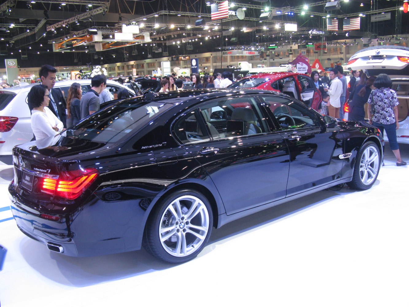 Rear side view of black luxury hybrid sedan with glowing tail lights