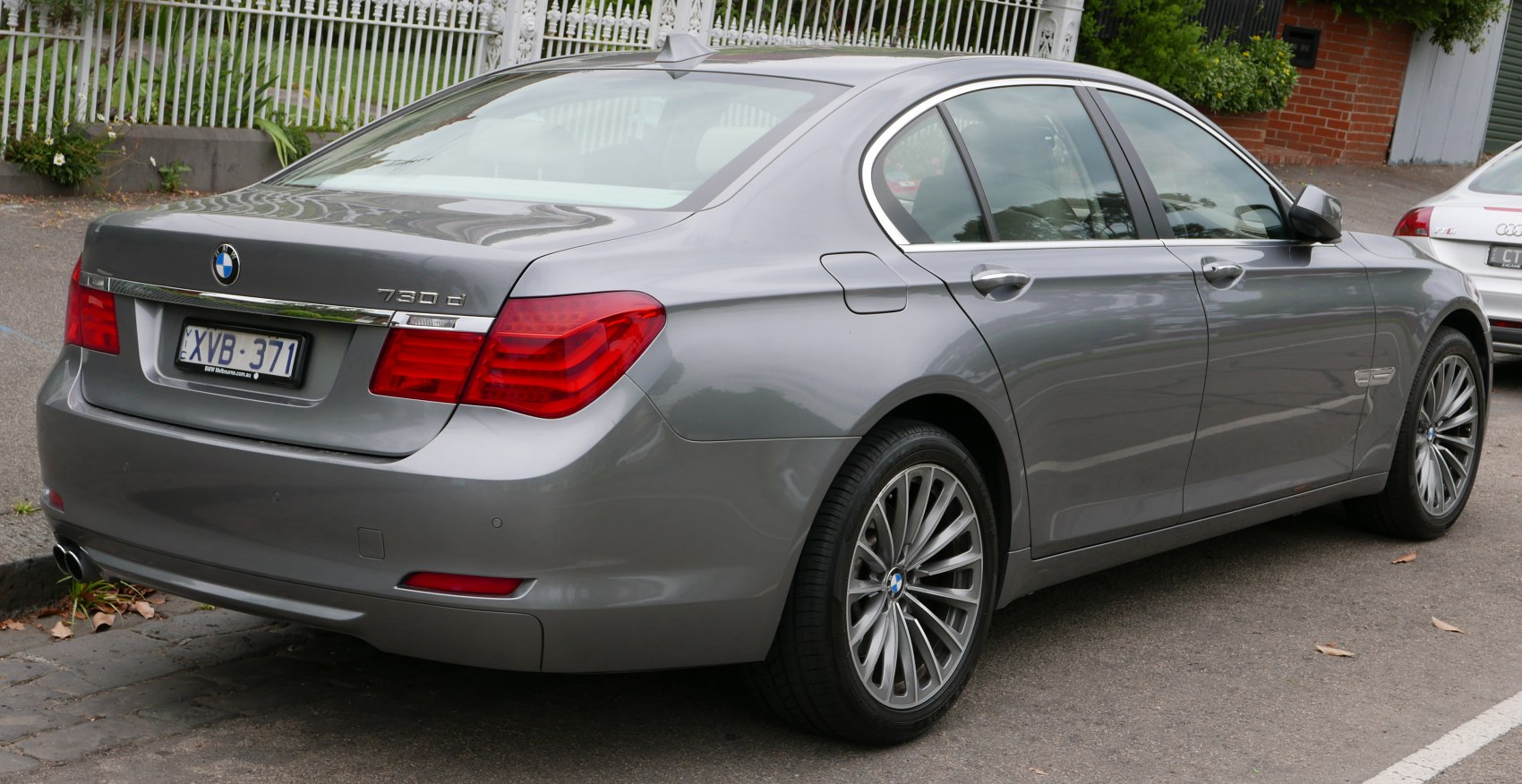 Rear side view of a grey luxury sedan with alloy wheels and distinct tail lights