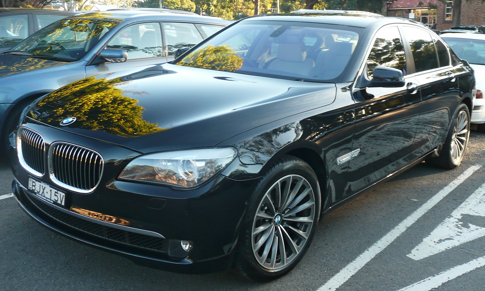Front angled view of luxury sedan with multi-spoke alloy wheels