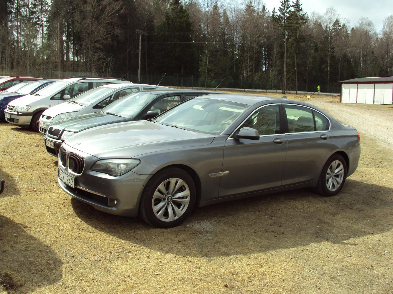 Grey luxury sedan parked showing front and side profile with alloy wheels.