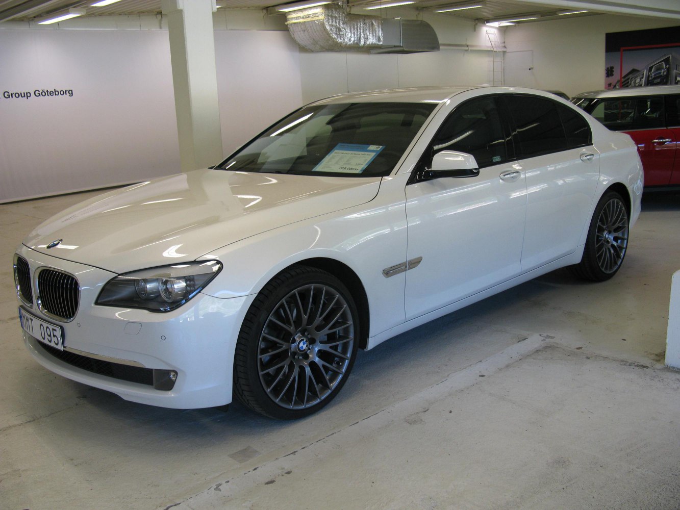 Luxury sedan with multi-spoke alloy wheels and sleek white body