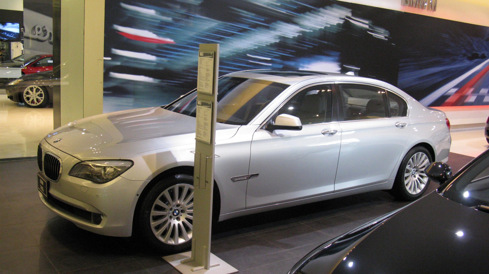 Luxury sedan side profile with alloy wheels and distinctive headlights
