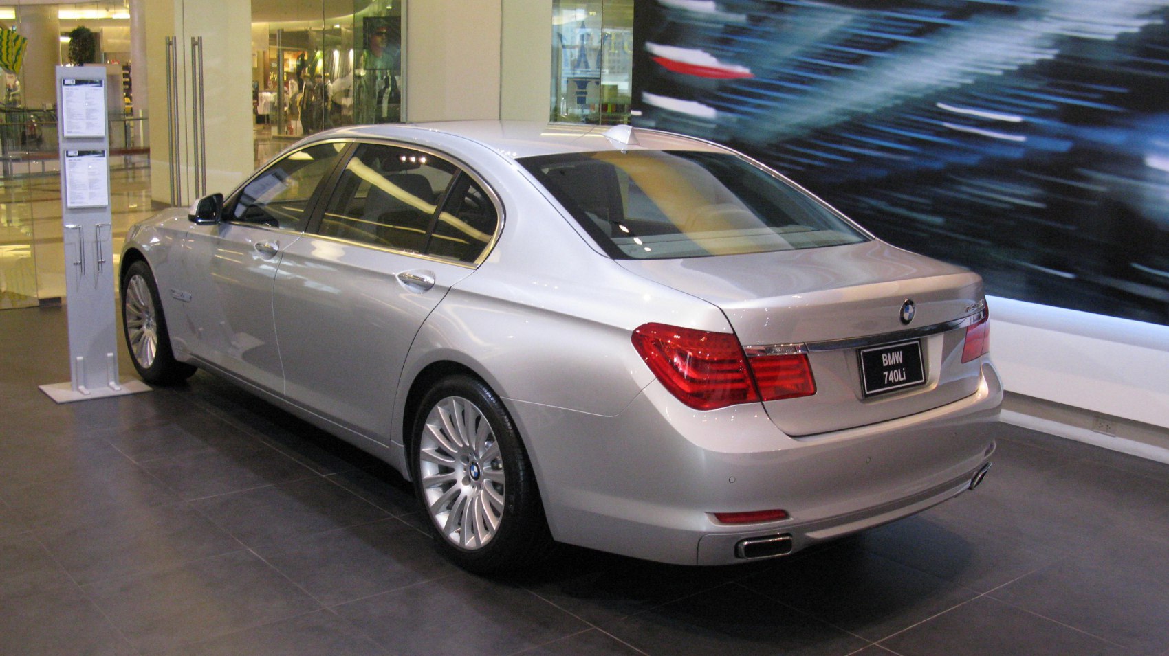 Rear side view of silver luxury sedan with distinctive taillights and alloy wheels