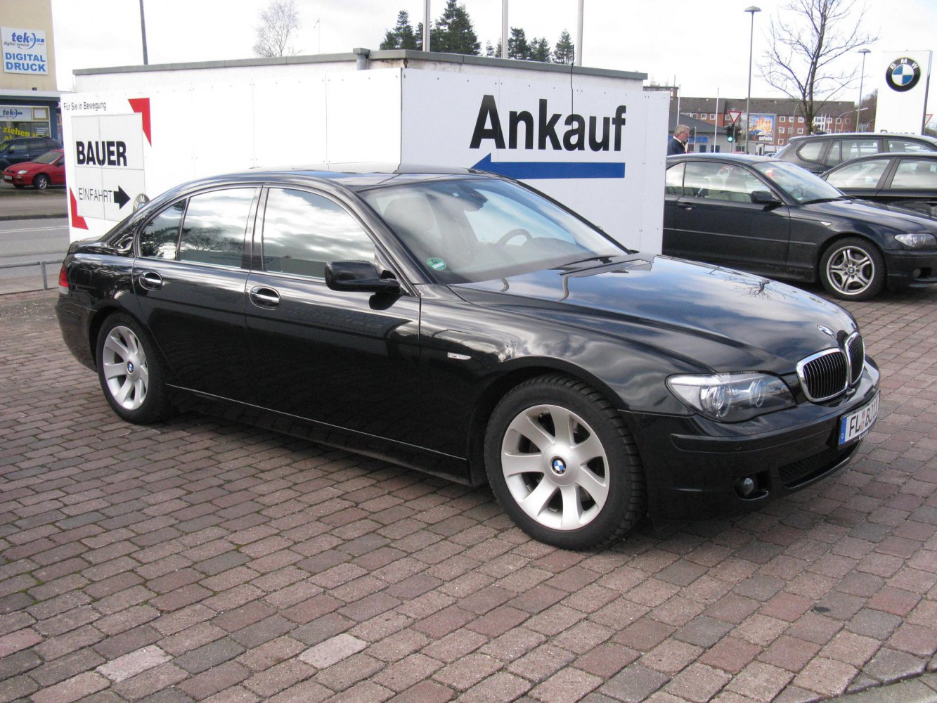 Black luxury sedan front side with alloy wheels and headlights