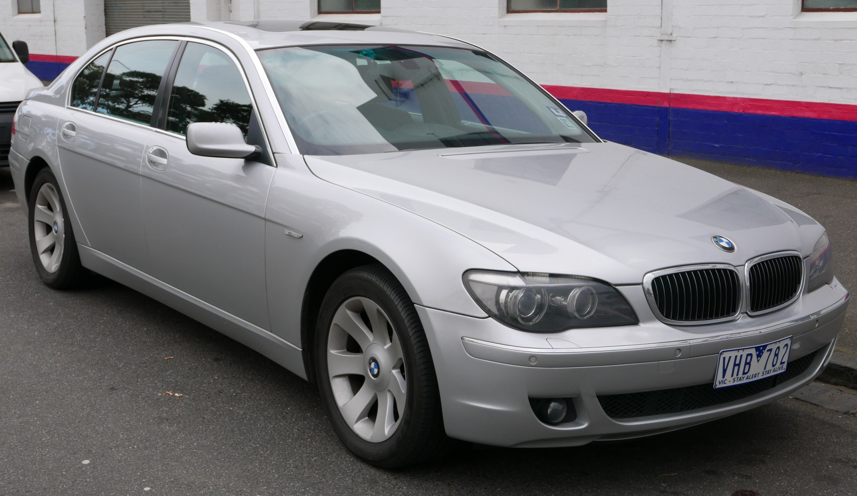 Silver luxury sedan front side with kidney grille and dual round headlights