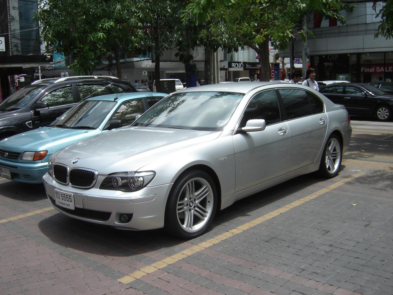 Silver luxury sedan with alloy wheels parked in urban setting