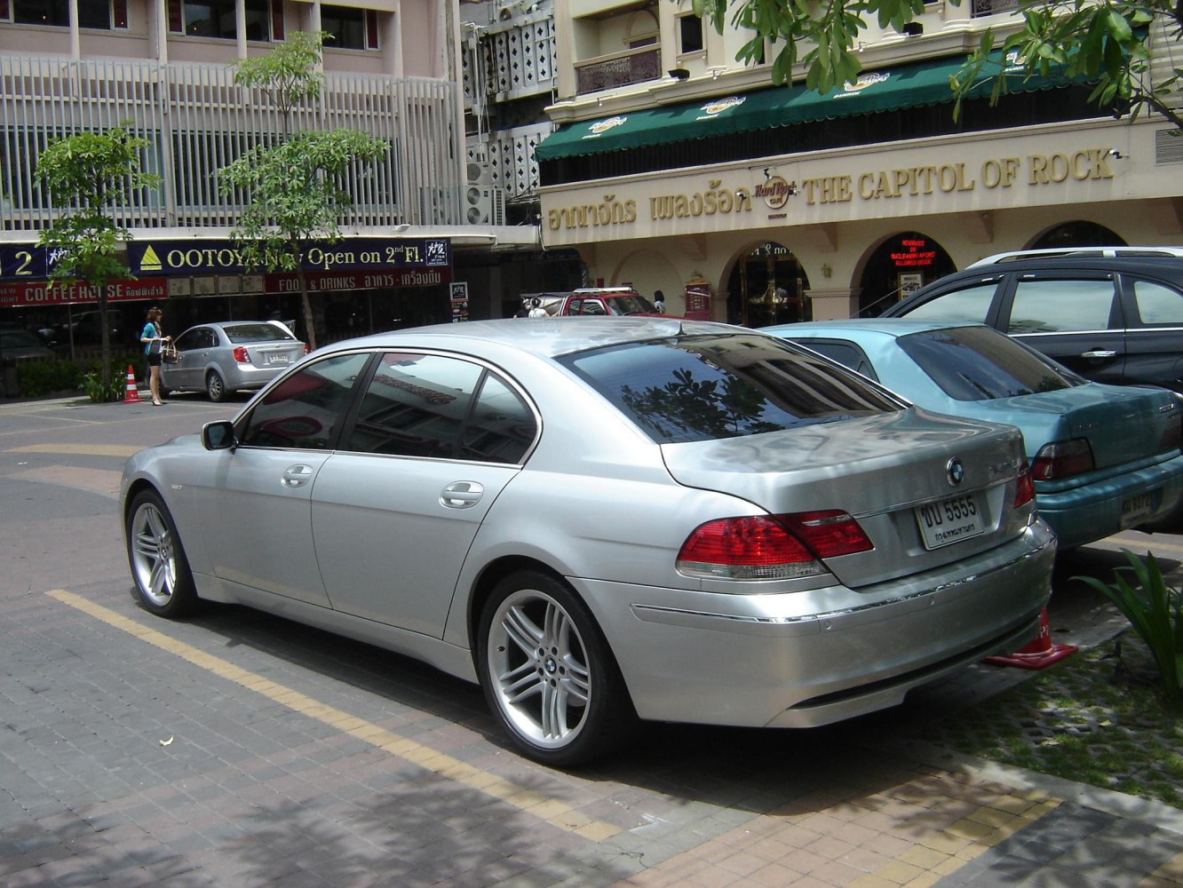 Rear and side view of a silver luxury sedan with distinctive taillights and alloy wheels.