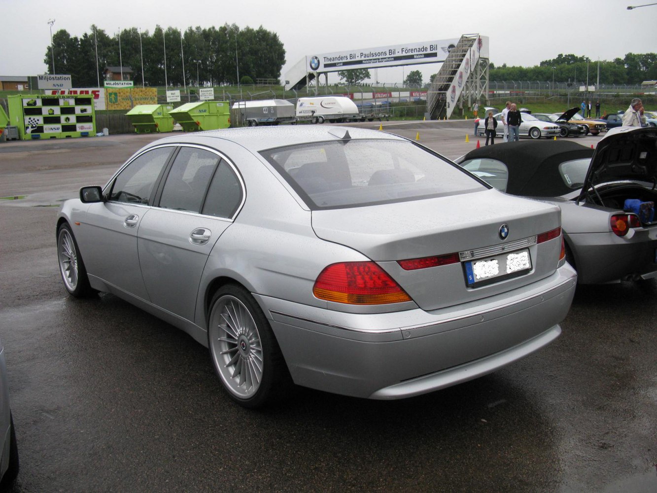 Rear three-quarter view of silver luxury sedan with wrap-around taillights and alloy wheels
