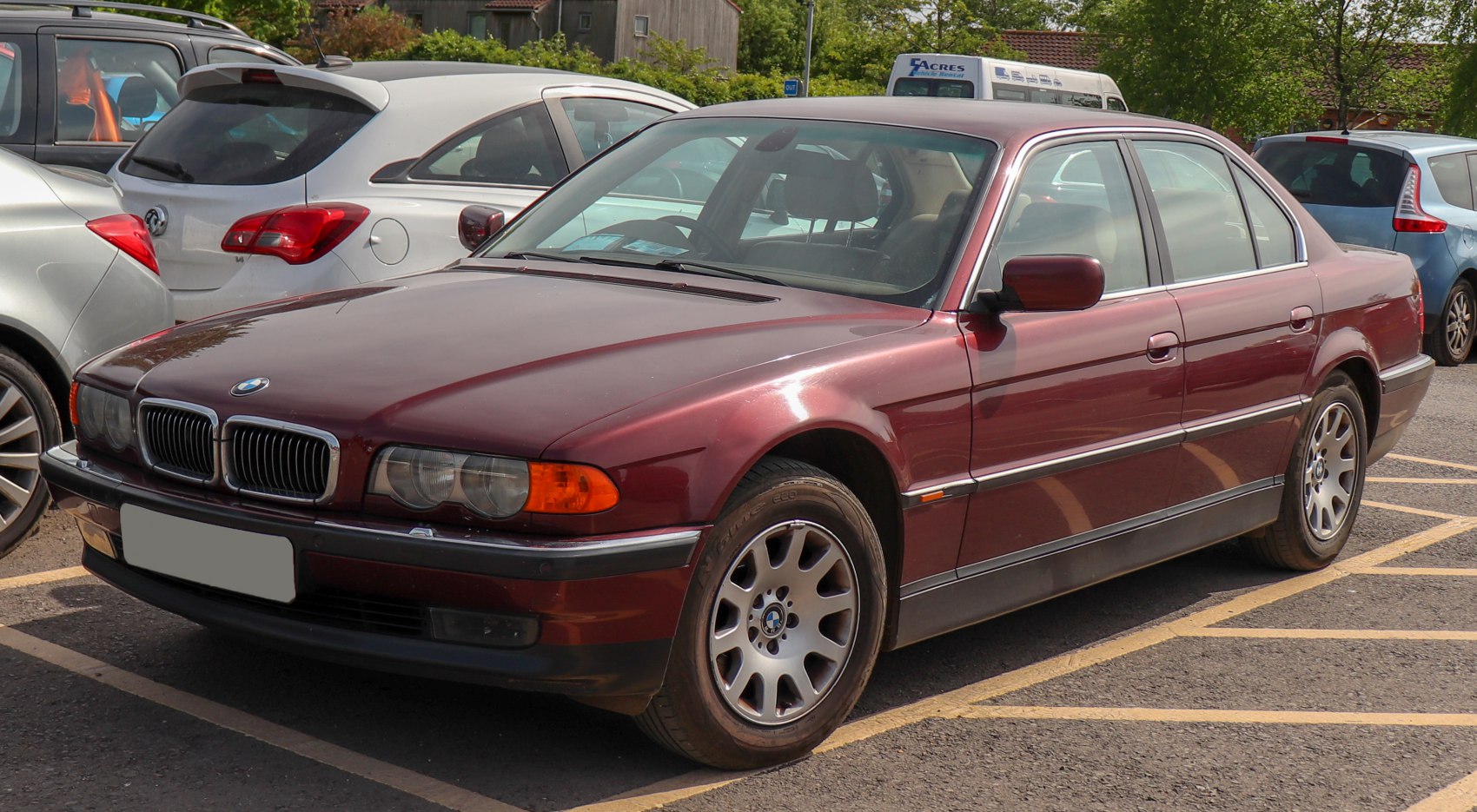Red sedan with alloy wheels, front side perspective