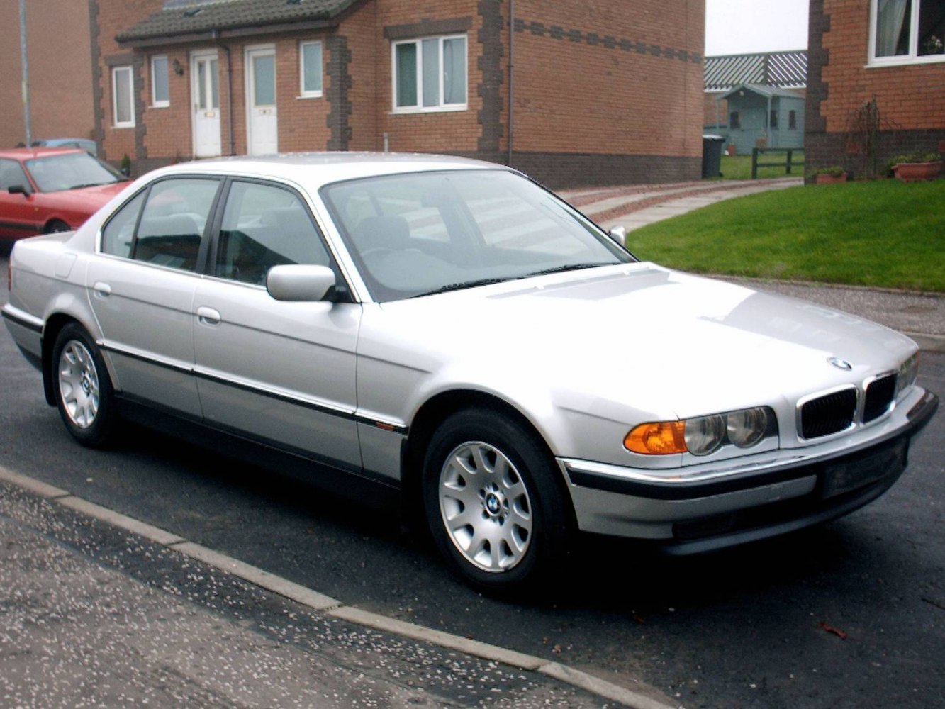 Silver sedan with classic BMW E38 facelift design and dual round headlights