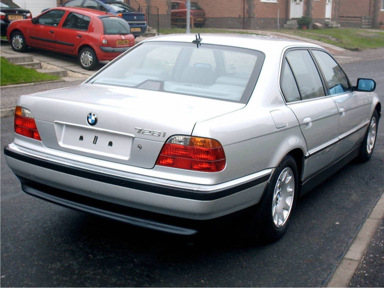 Rear view of silver luxury sedan with distinctive taillights and five-spoke wheels
