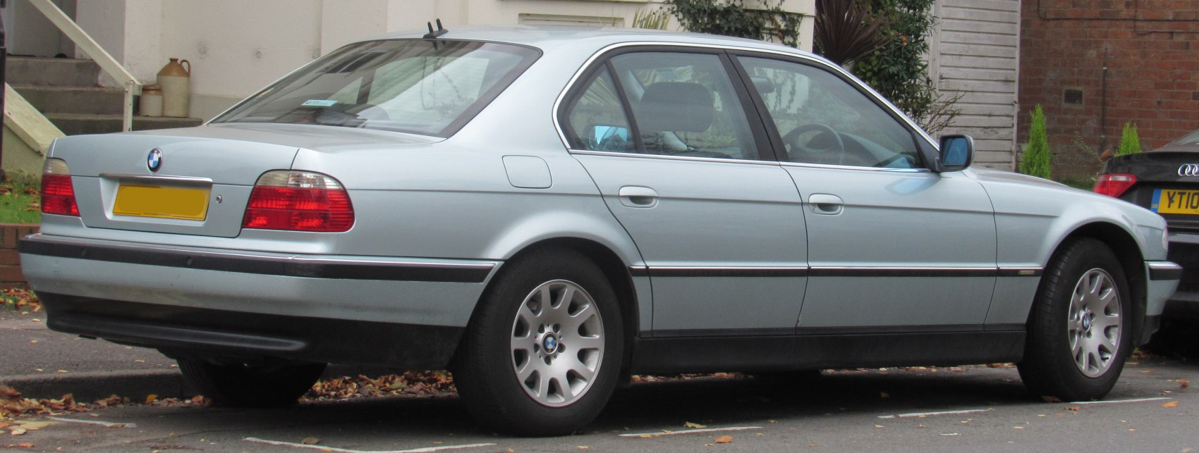 Silver sedan rear side view, alloy wheels, distinct taillights