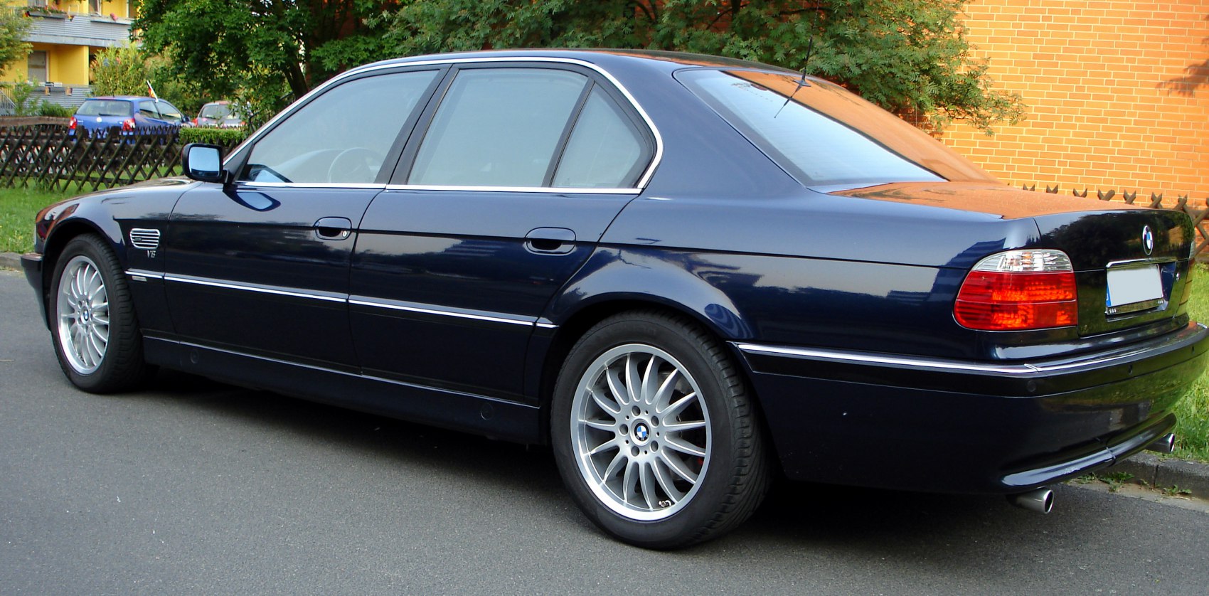 Luxury sedan side profile with alloy wheels and V8 badge