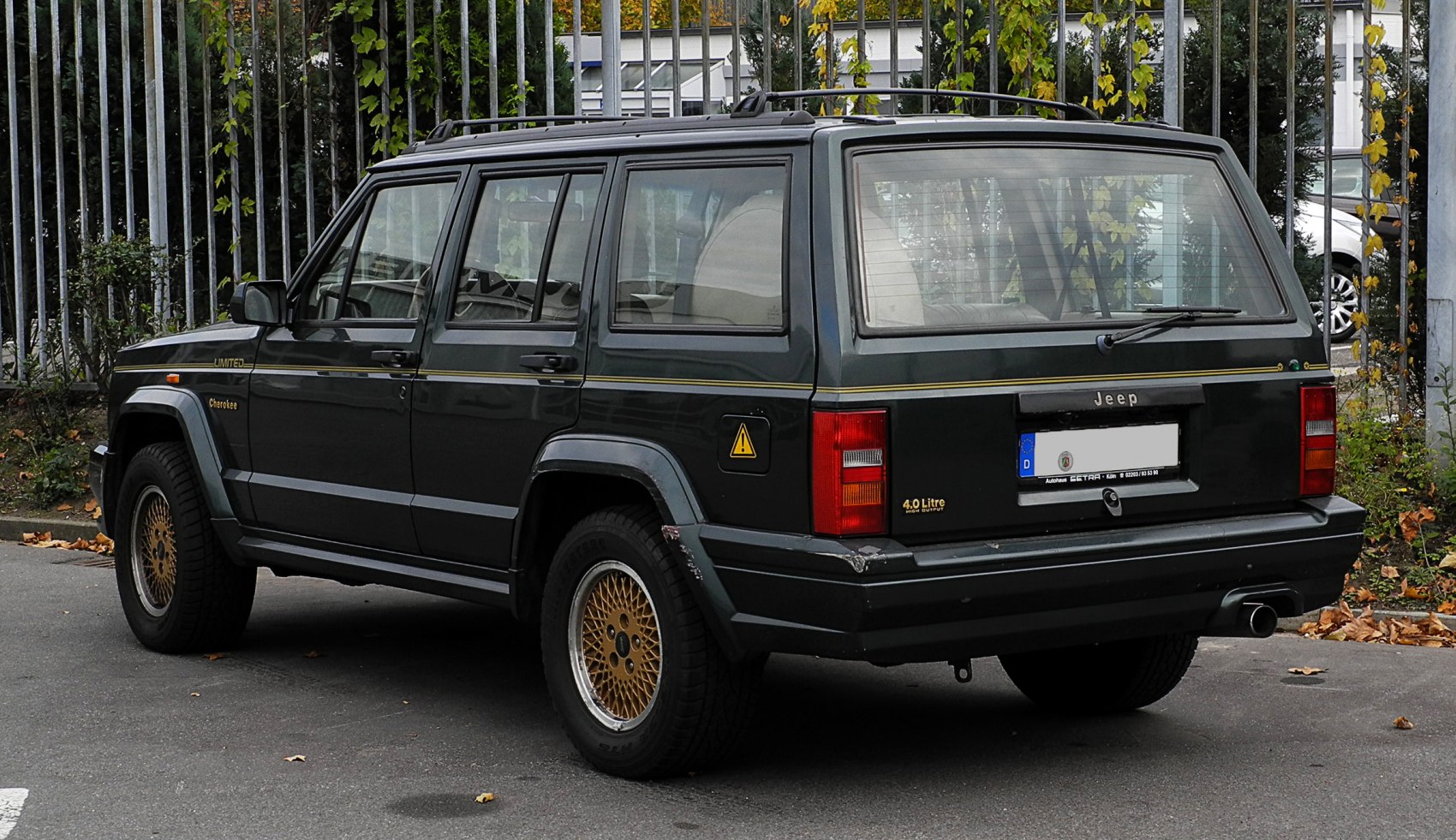 Vintage 5-door SUV rear view with mesh wheels and roof rack