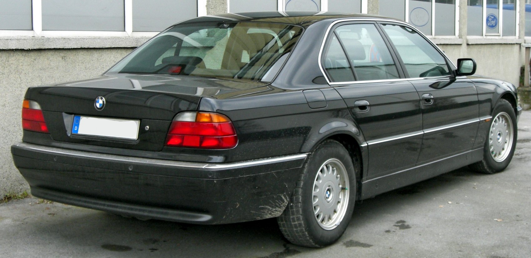 Rear three-quarter view of classic luxury sedan with distinct tail lights and alloy wheels