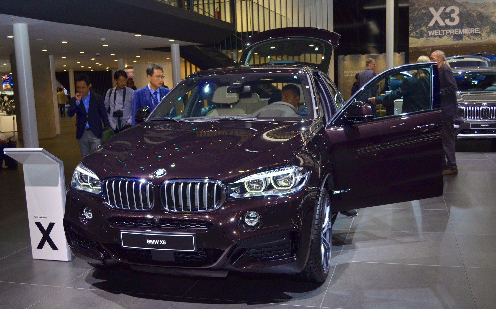 Front view with kidney grille, LED headlights, open driver door and trunk