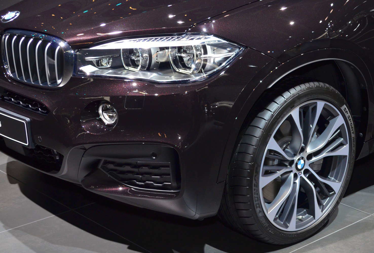 Close-up of front LED headlight and alloy wheel