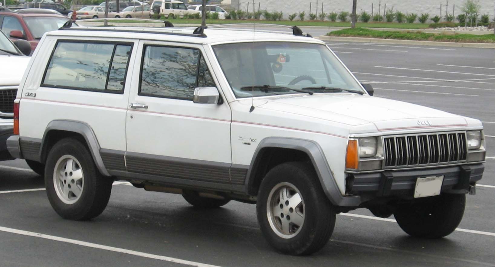 Boxy white SUV with roof rack and seven-slot grille in side view