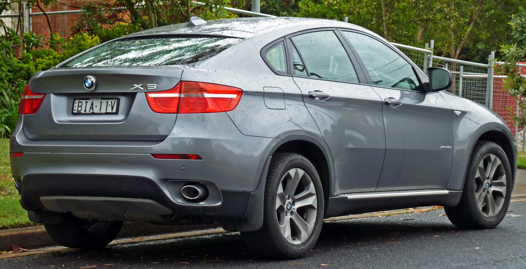 Rear and side view of a grey sporty SUV with alloy wheels and rear exhaust.