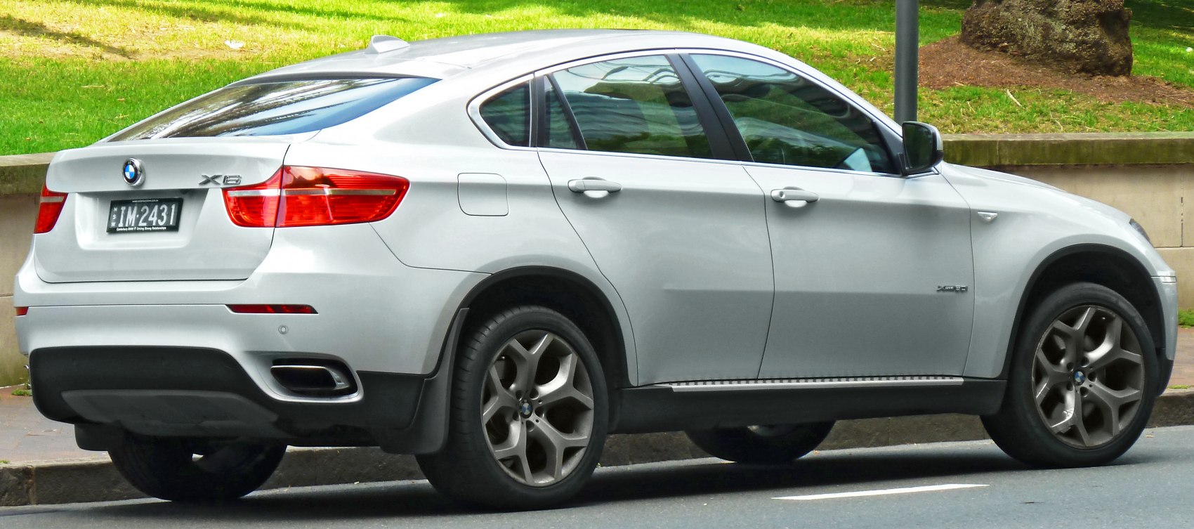 Rear side view of silver SUV with coupe design and alloy wheels