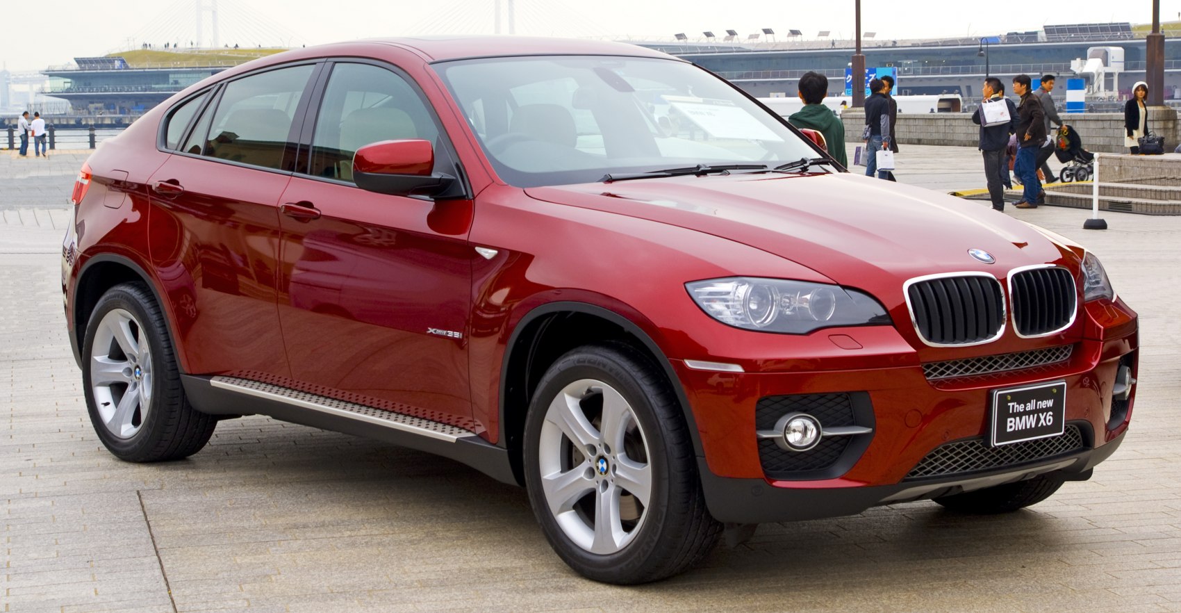 Front side view of red sporty SUV with kidney grille and alloy wheels