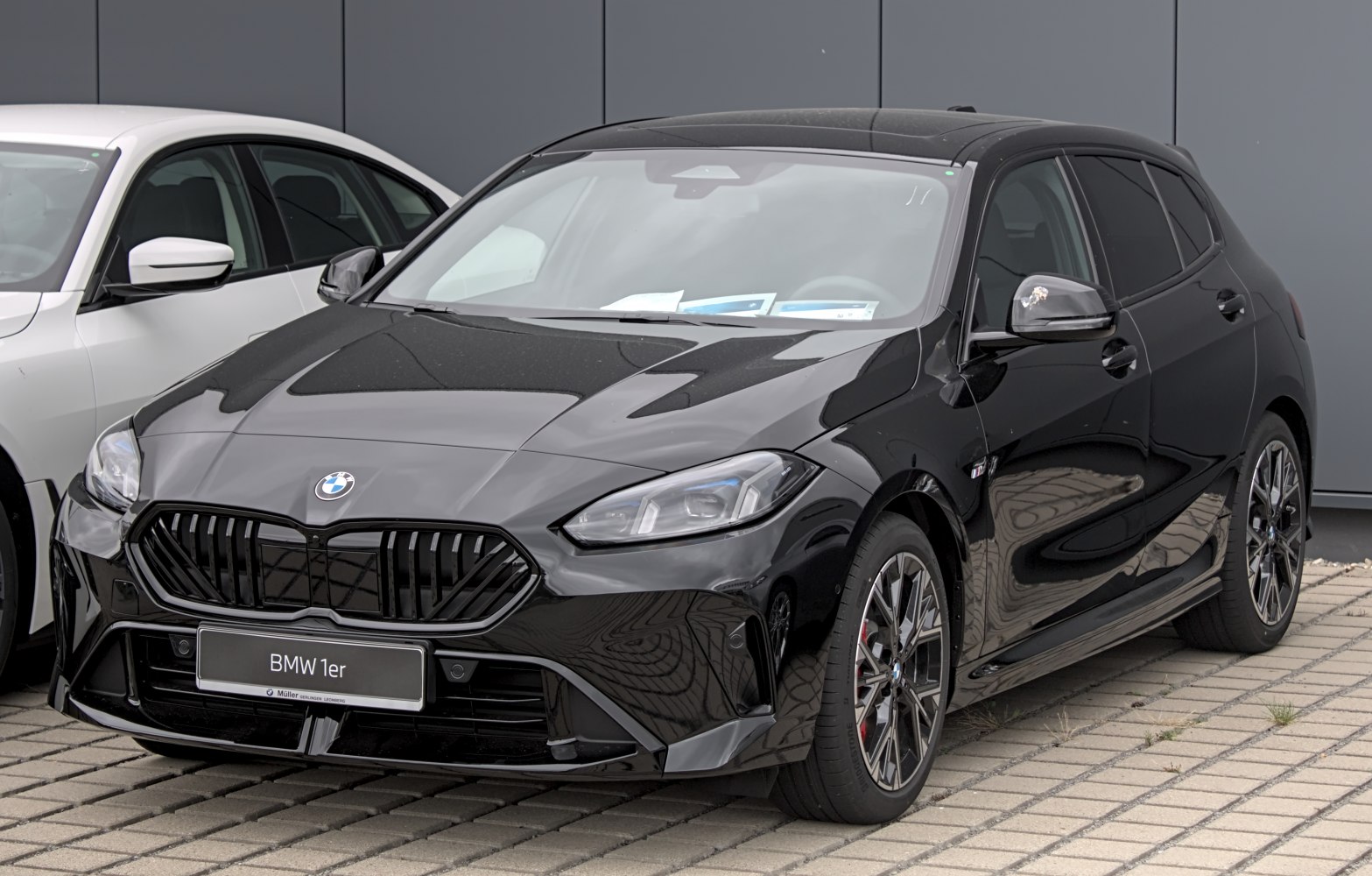 Black hatchback with prominent front grille and sporty alloy wheels