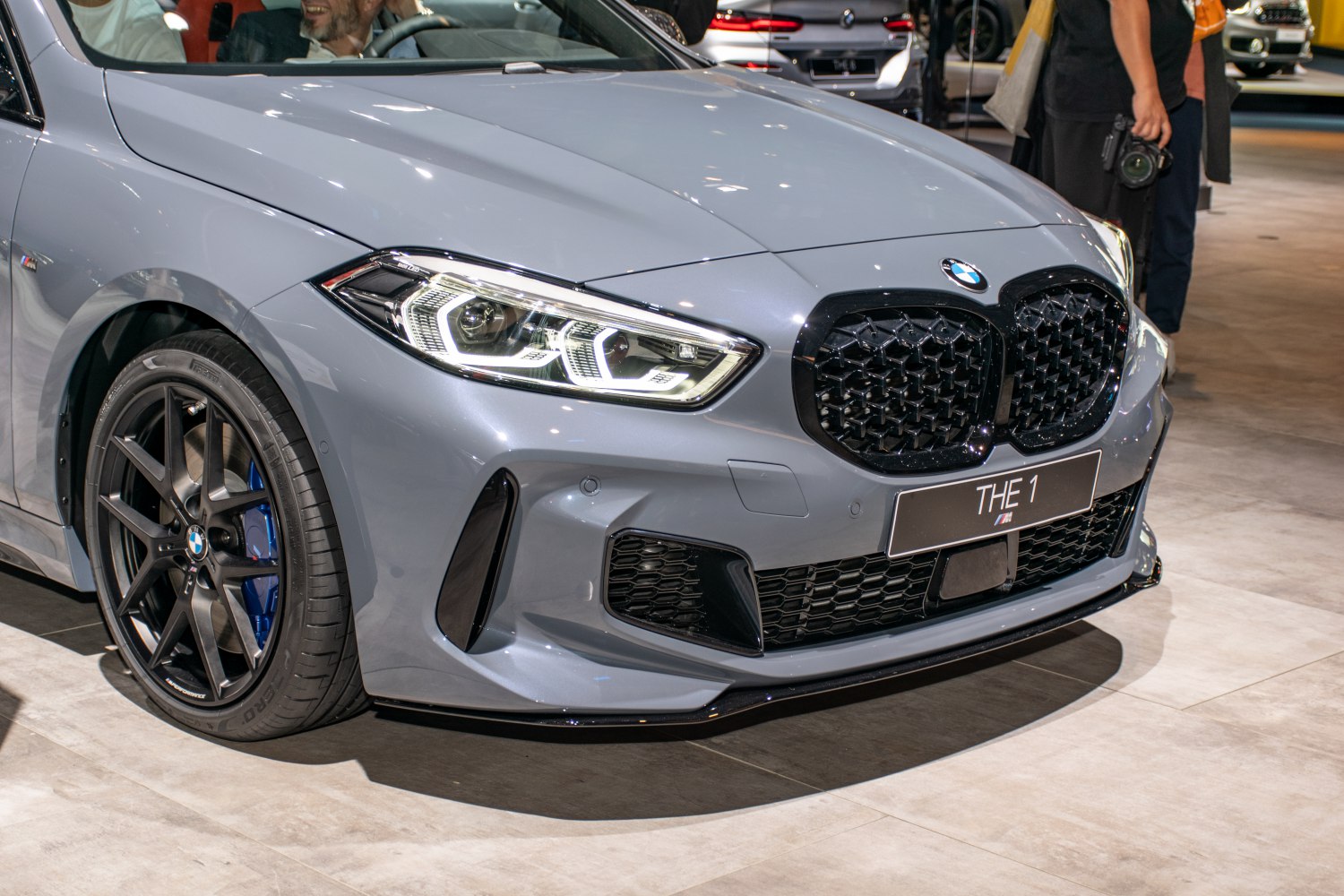 Close-up of front grille, headlights, and front wheel of sporty hatchback
