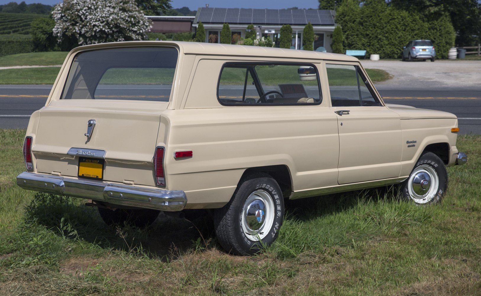 Rear side view of a classic 3-door vintage SUV with rugged steel wheels and beige color