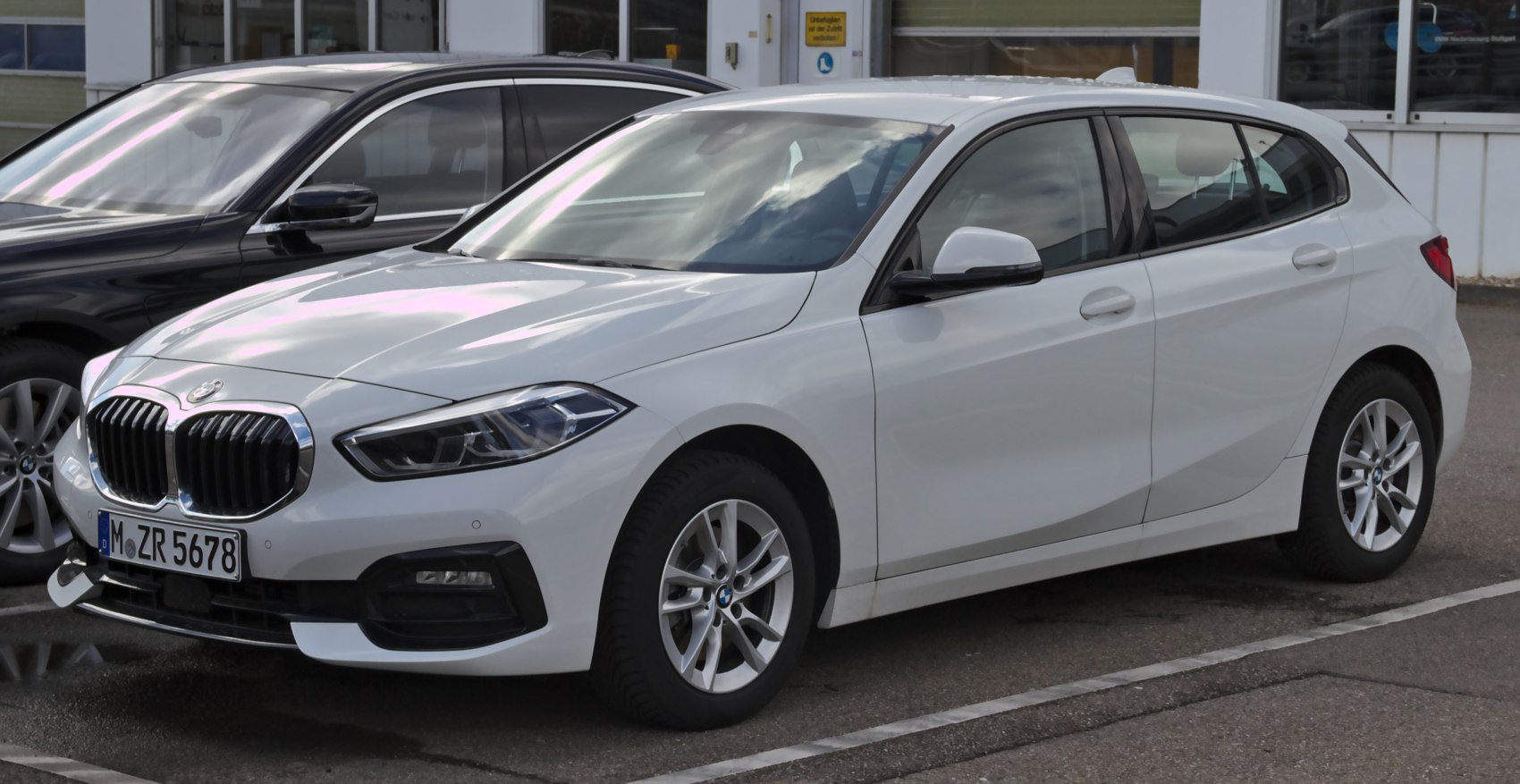 Front-side view of a white hatchback with kidney grille and modern headlights