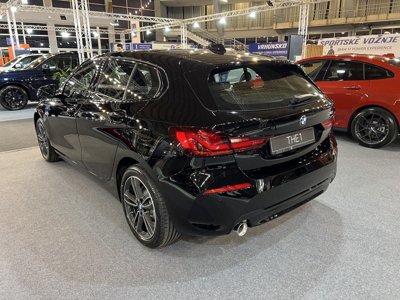 Rear and side view of black hatchback with distinct taillights and single exhaust