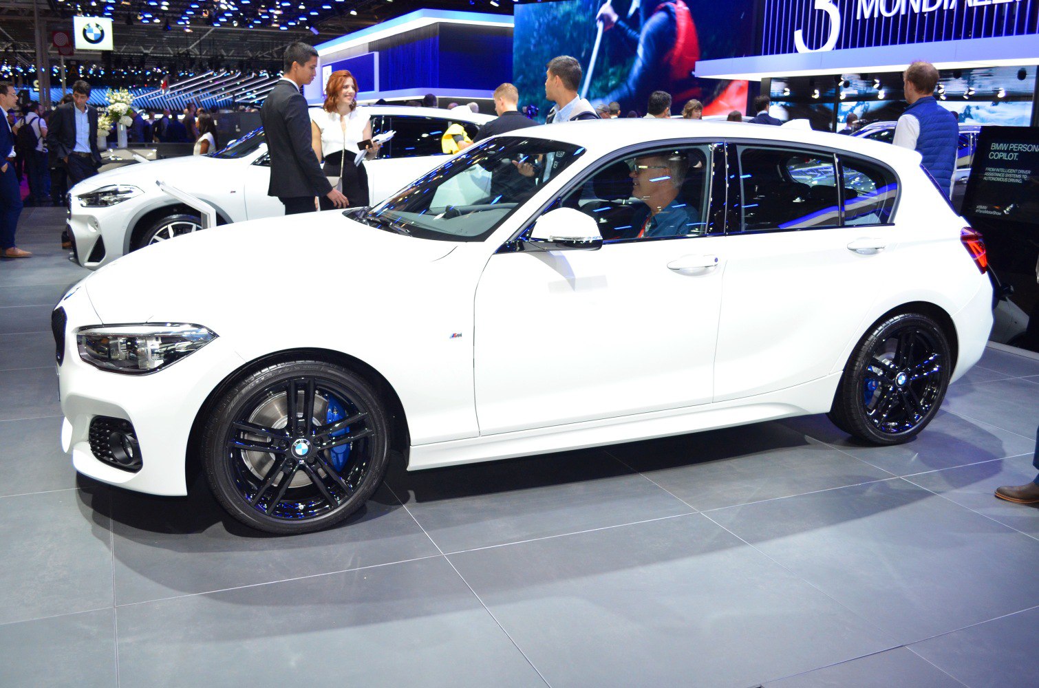 White hatchback with black alloy wheels and M Sport badging.