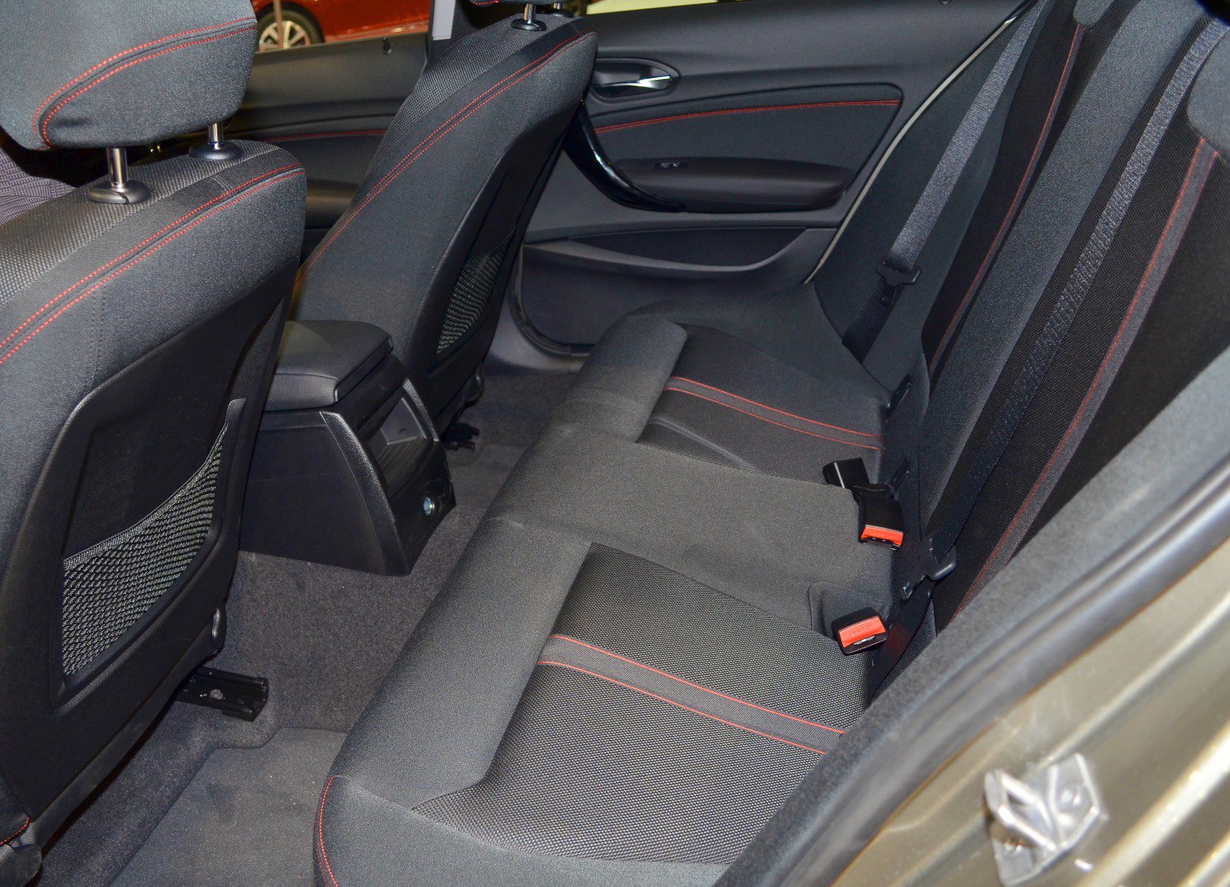 Rear passenger seats with fabric upholstery and red stitching