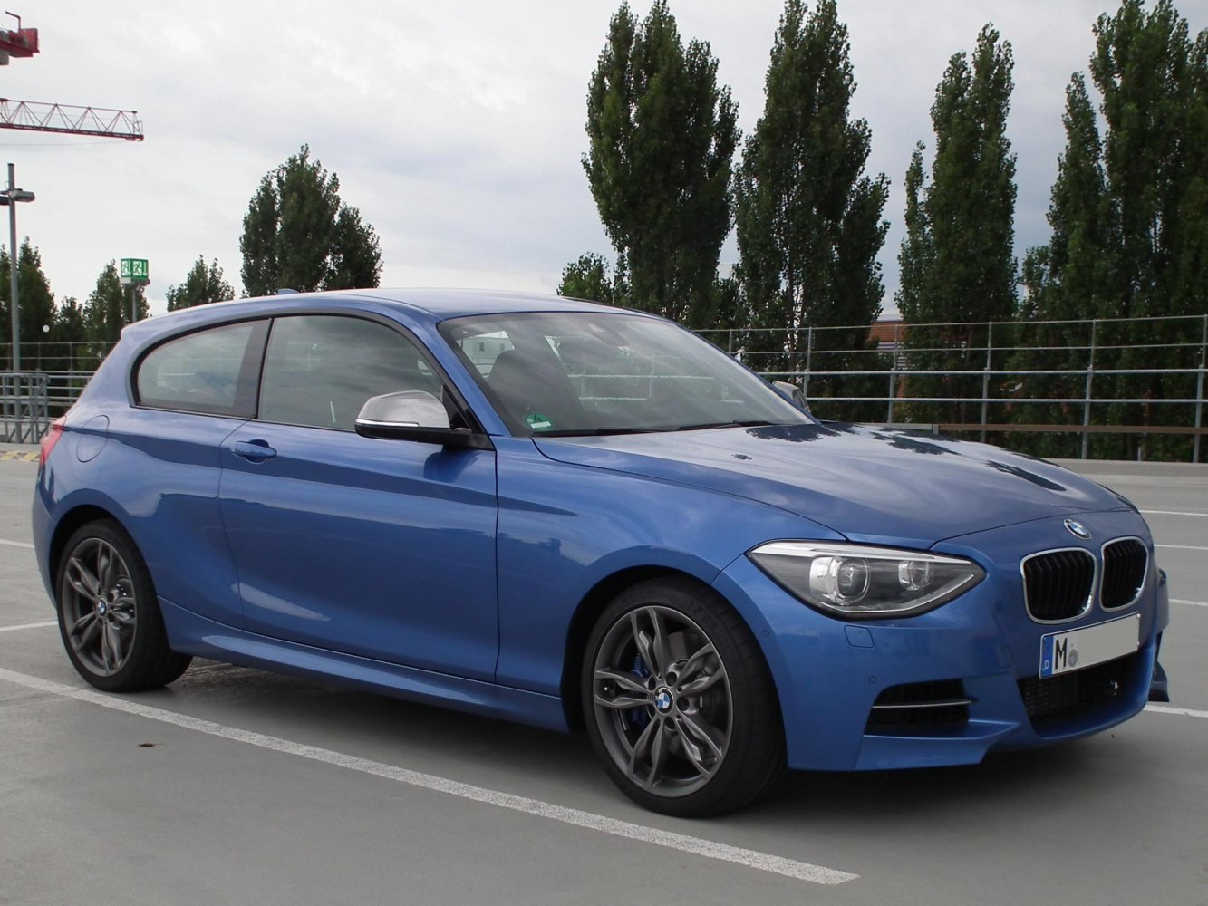 Blue sporty 3-door hatchback front side view with alloy wheels