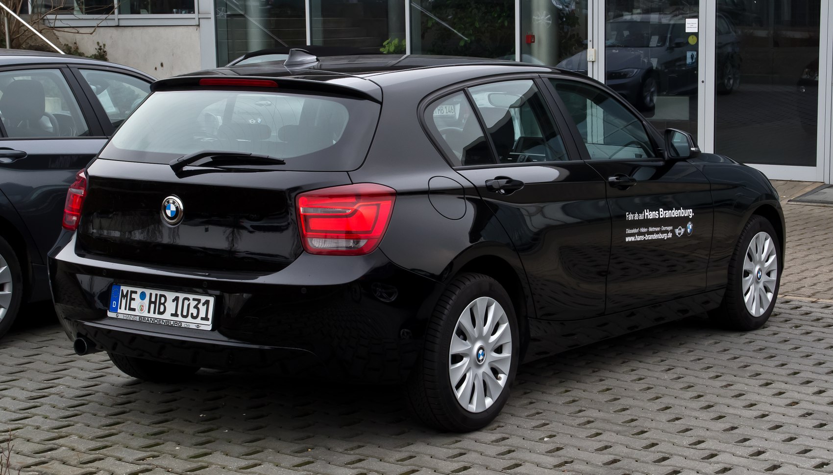 Rear and side profile of a black 5-door hatchback with distinct taillights and alloy wheels