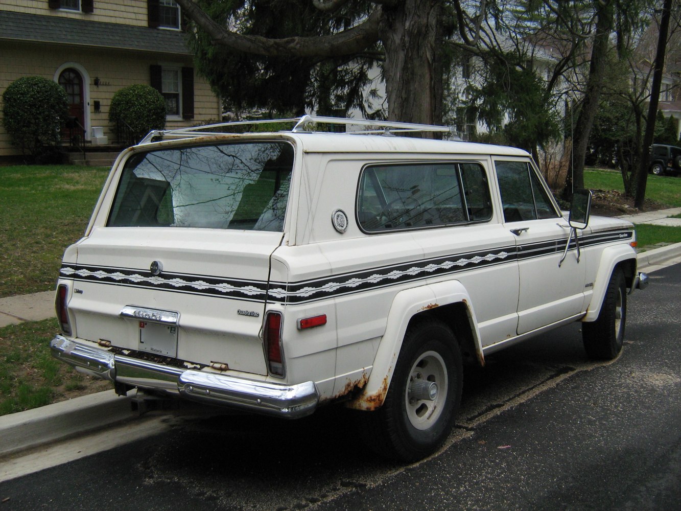Rear view of a vintage SUV with 3-door and retro side decals.