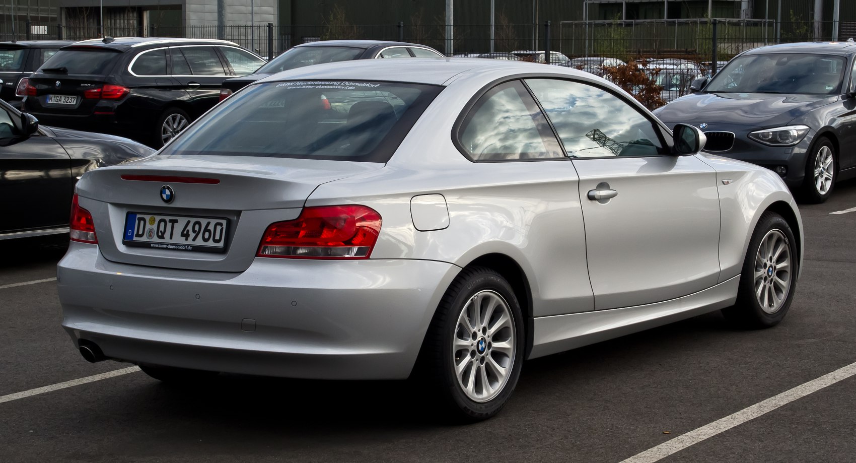 Silver coupe rear side with distinct tail lights and alloy wheels