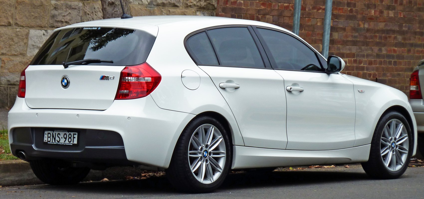 Rear and side profile of a white 5-door hatchback with alloy wheels