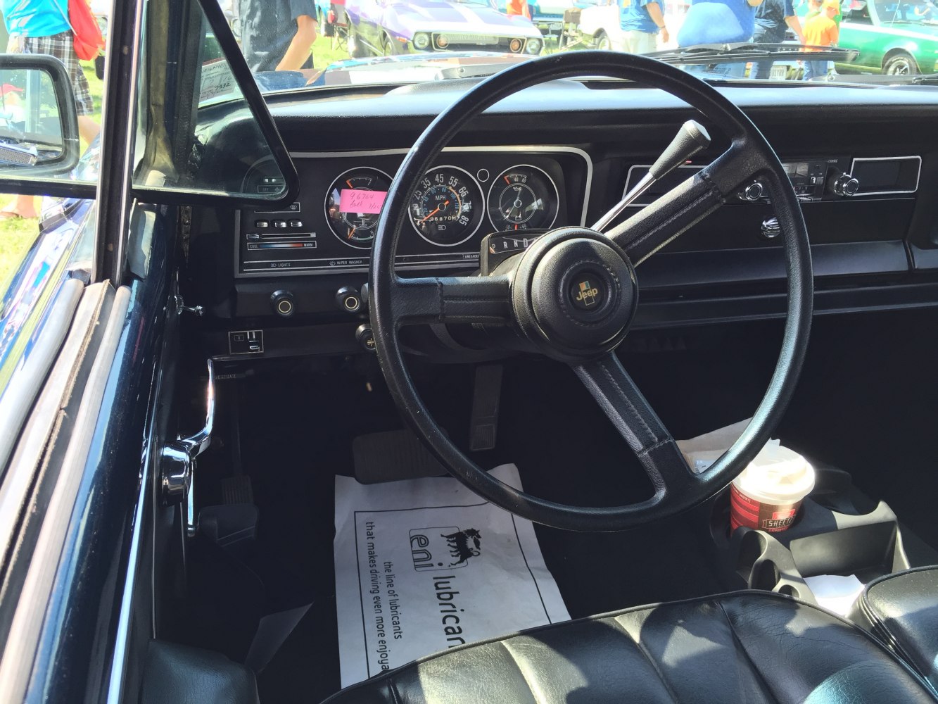 Classic vintage car dashboard and steering wheel with analog gauges and simple controls.