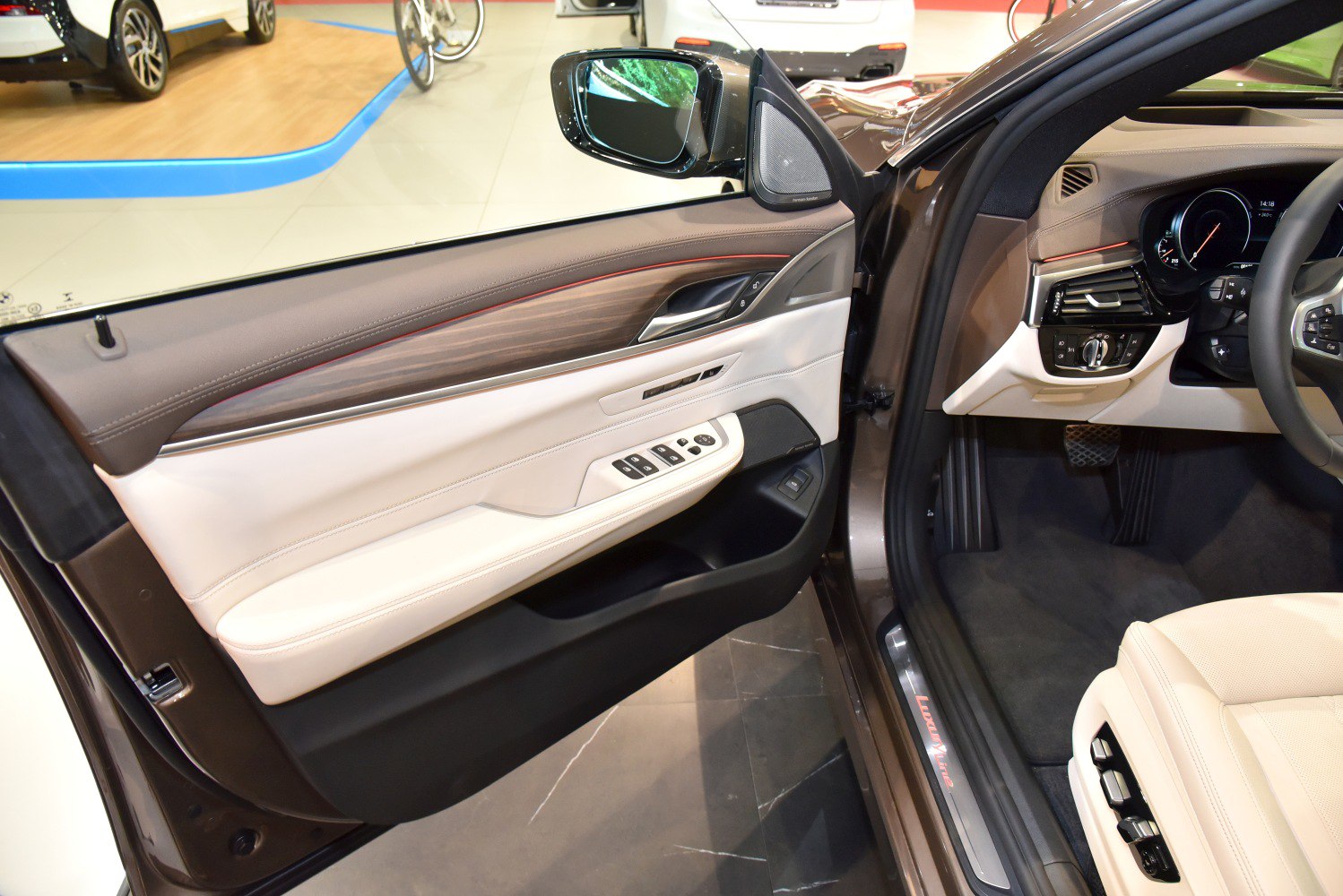 Driver-side interior door panel and seat controls with wood trim and ambient lighting