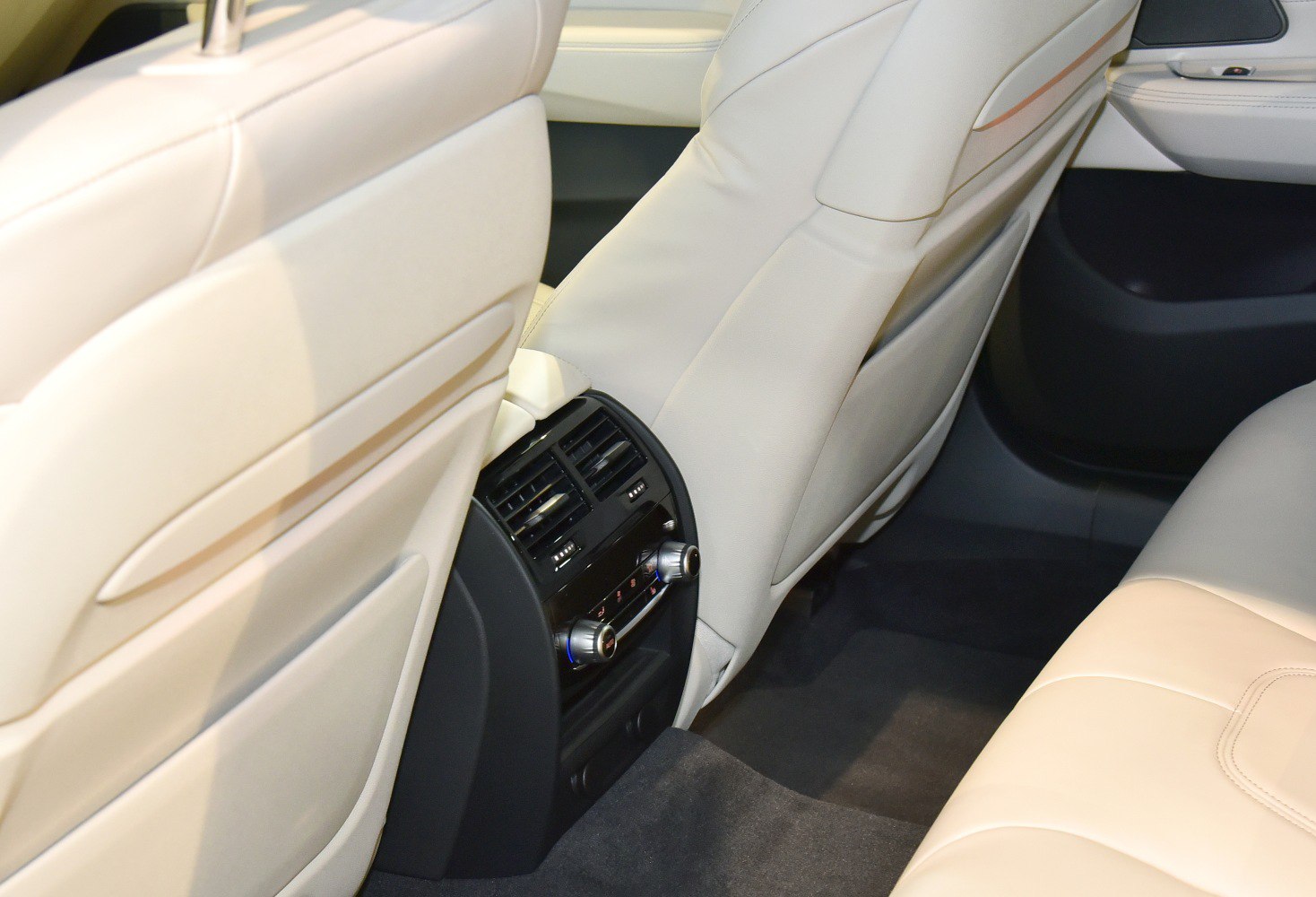 Beige leather seats with rear air vents and climate control panel